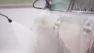 Čovek pere auto u auto perionici