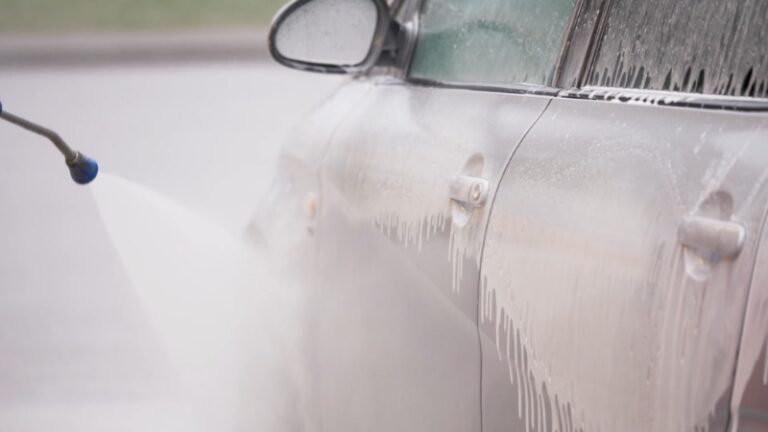 Čovek pere auto u auto perionici