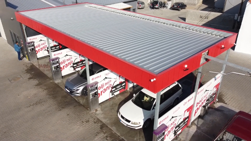 Snimak iz vazduha prikazuje modernu samouslužnu auto perionicu sa više bokseva