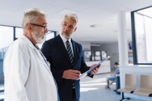 Lekar i menadžer razgovaraju u zdravstvenoj ustanovi o organizaciji i kvalitetu usluge